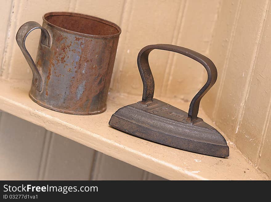 An old iron and mug on a shelf