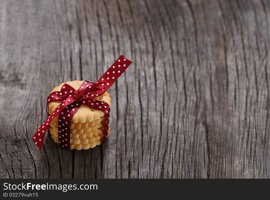 Cookies decorated with dark red polka dots ribbon on the wooden background. Cookies decorated with dark red polka dots ribbon on the wooden background