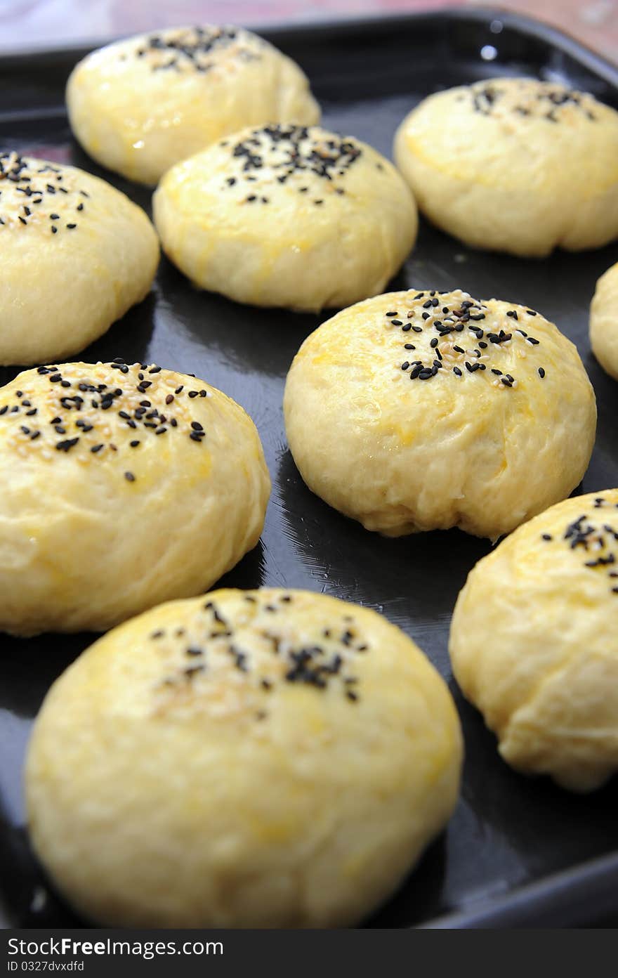 Close up of unbaked homemade buns with sesame top. Close up of unbaked homemade buns with sesame top.