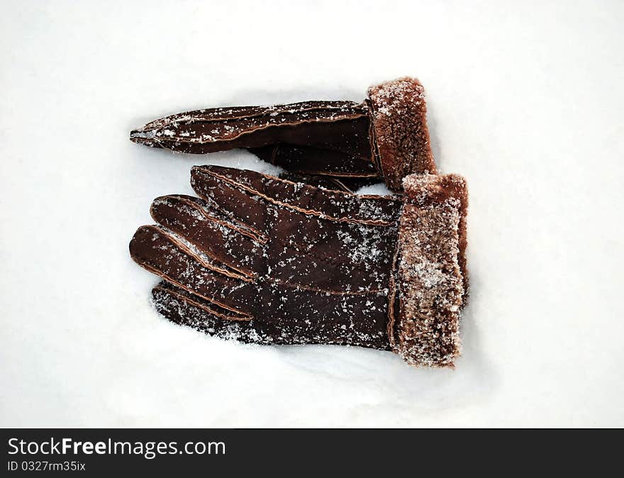 Brown man's gloves on a white snow. Brown man's gloves on a white snow