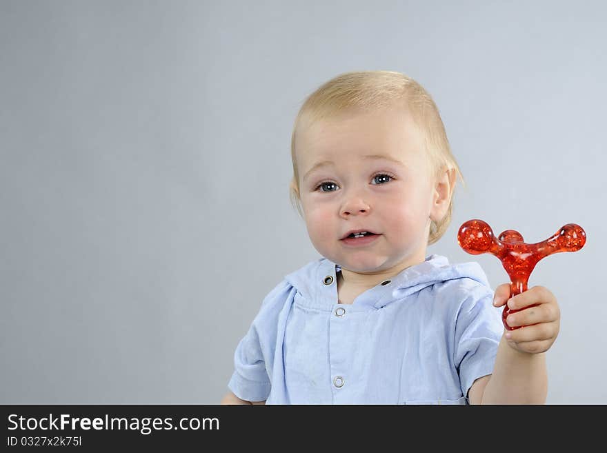 Beautiful baby boy having fun with red toy. Beautiful baby boy having fun with red toy