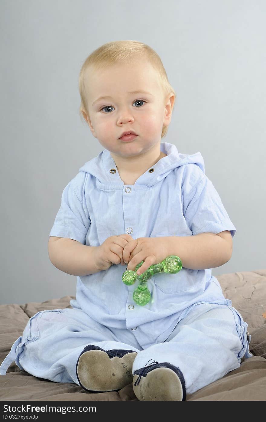 Beautiful baby boy having fun with green toy. Beautiful baby boy having fun with green toy