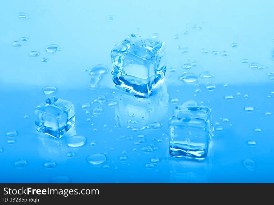 Three blue Ice cubes with water drops