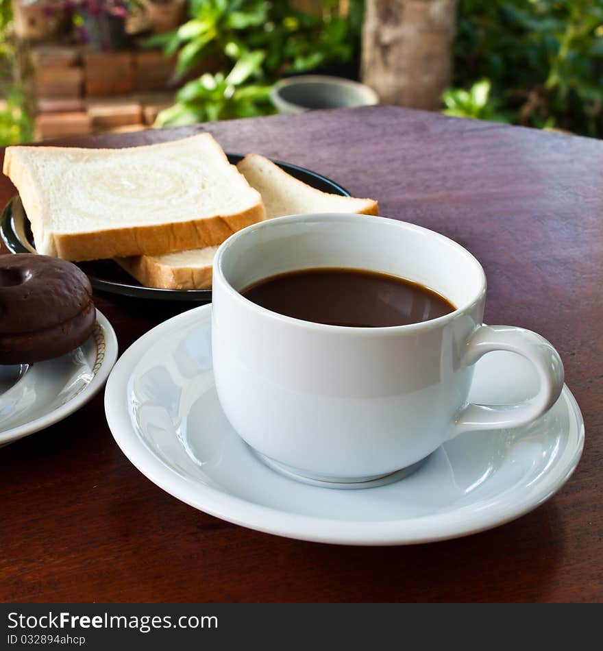 Cup of coffee and bread on table