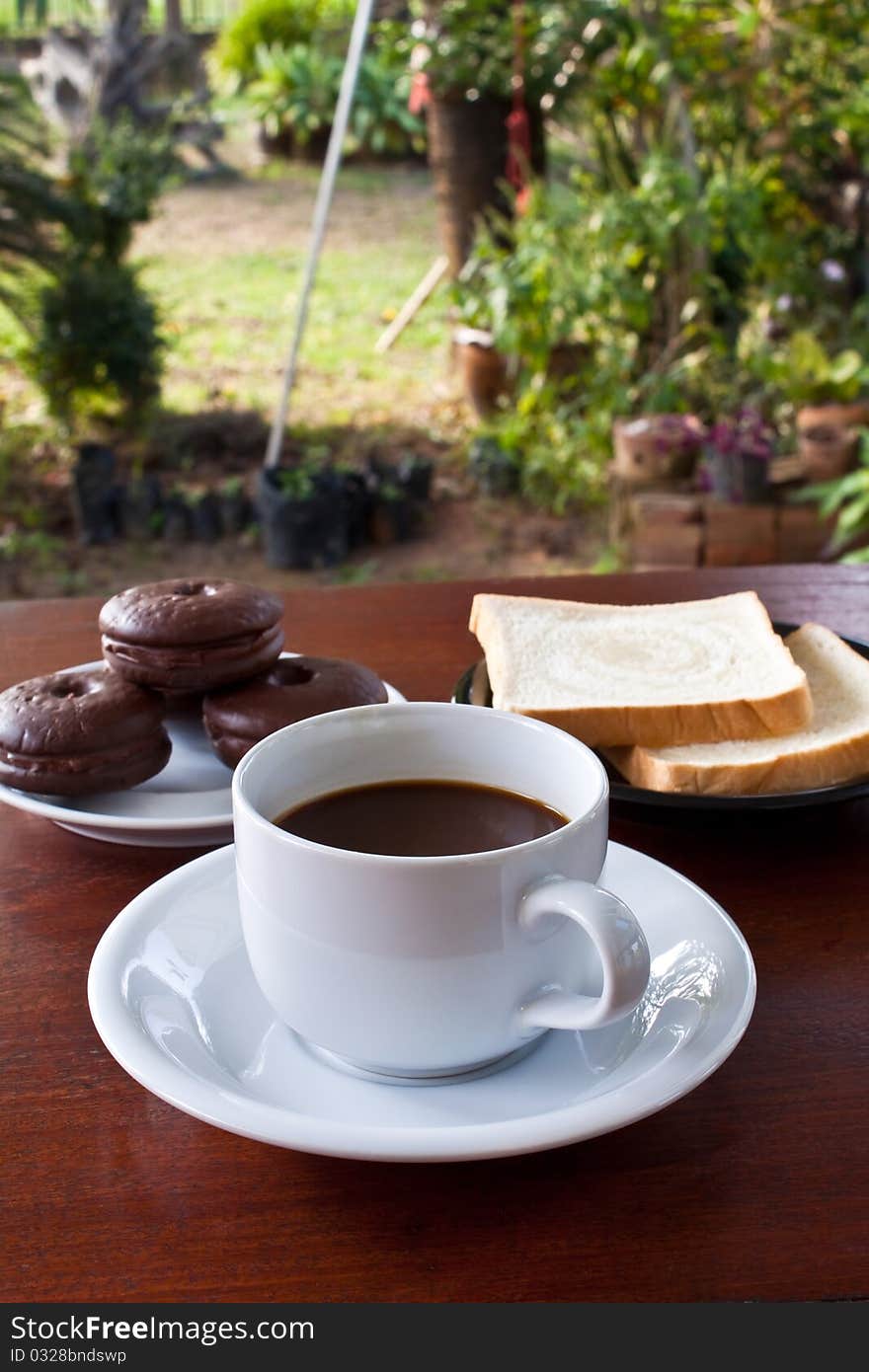 Cup of coffee and bread on table