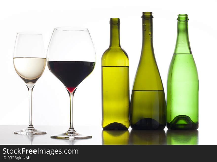 Two glass of red and white wine with three glass bottles. Two glass of red and white wine with three glass bottles