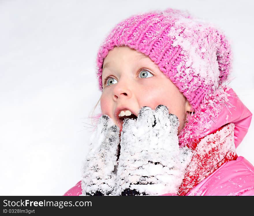 Little girl in winter pink hat in snow . Little girl in winter pink hat in snow .