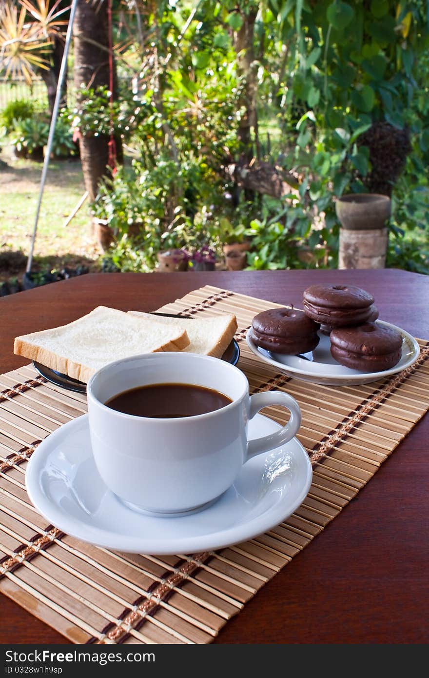 Cup of coffee and bread on table