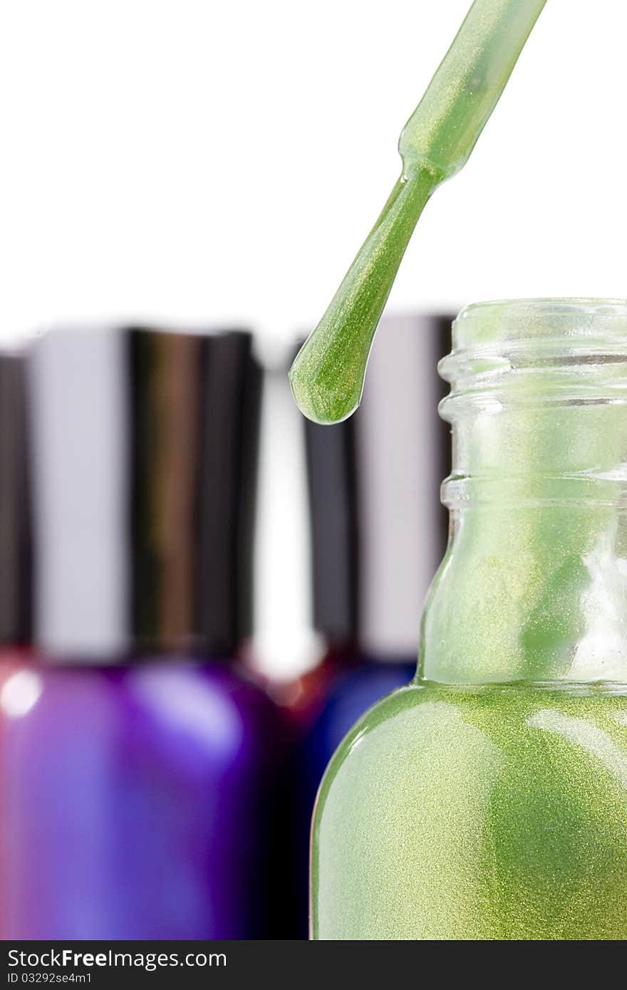 Nail polish brush next to a bottle with green nail polish.