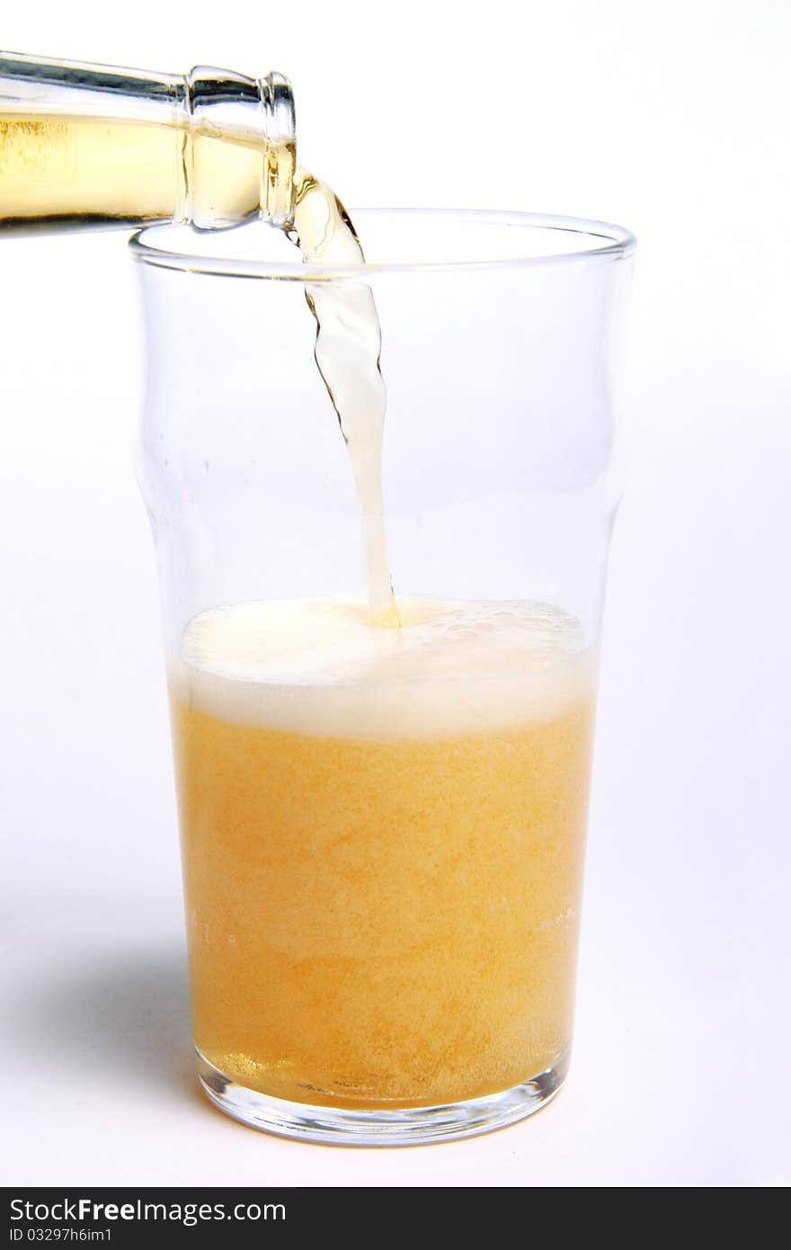 Pouring beer into a glass isolated on white