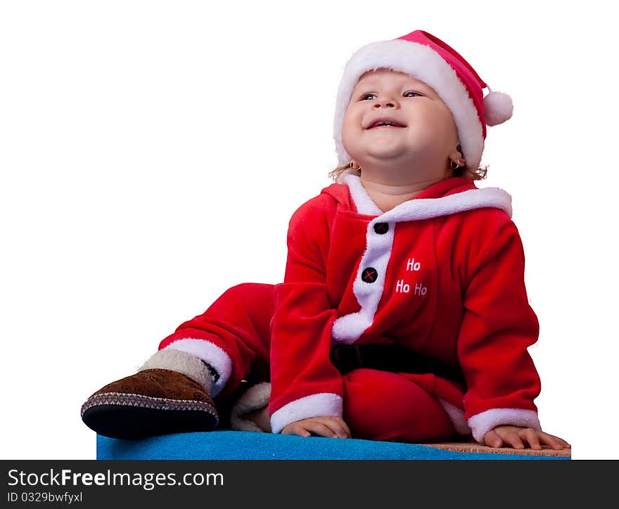 The wonderful kid with a naughty smile sits in a suit and a cap of Santa Claus. The wonderful kid with a naughty smile sits in a suit and a cap of Santa Claus