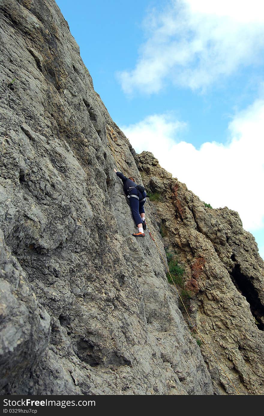 Girl rock climber conquers mountain