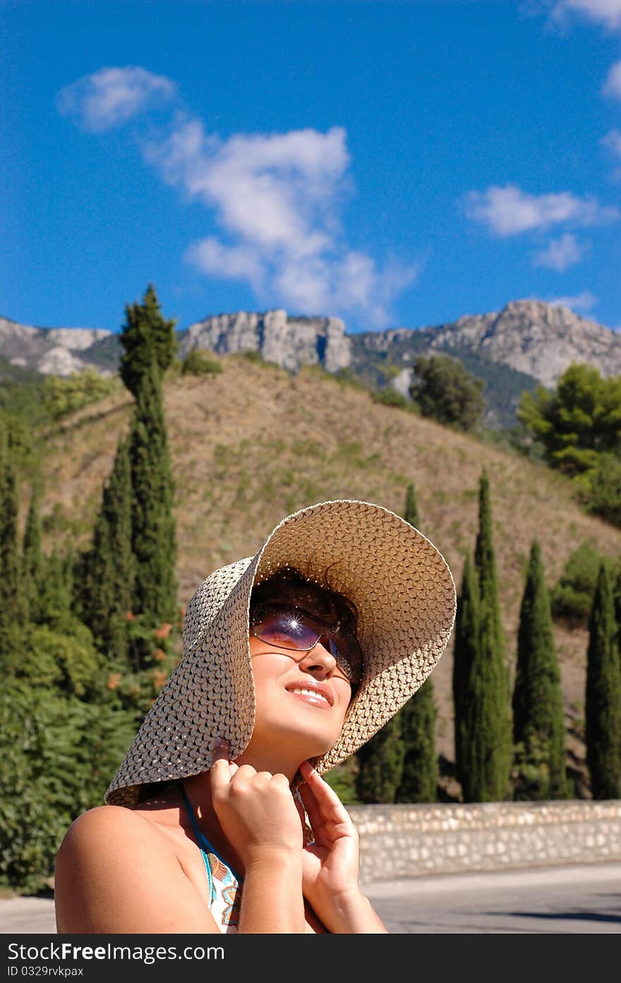 Girl in a hat on a background of mountains