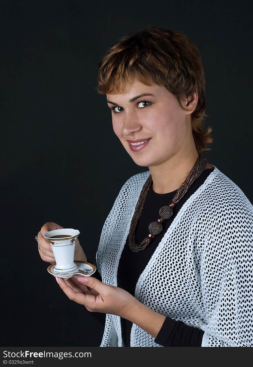 Girl with a cup of coffee on a dark background