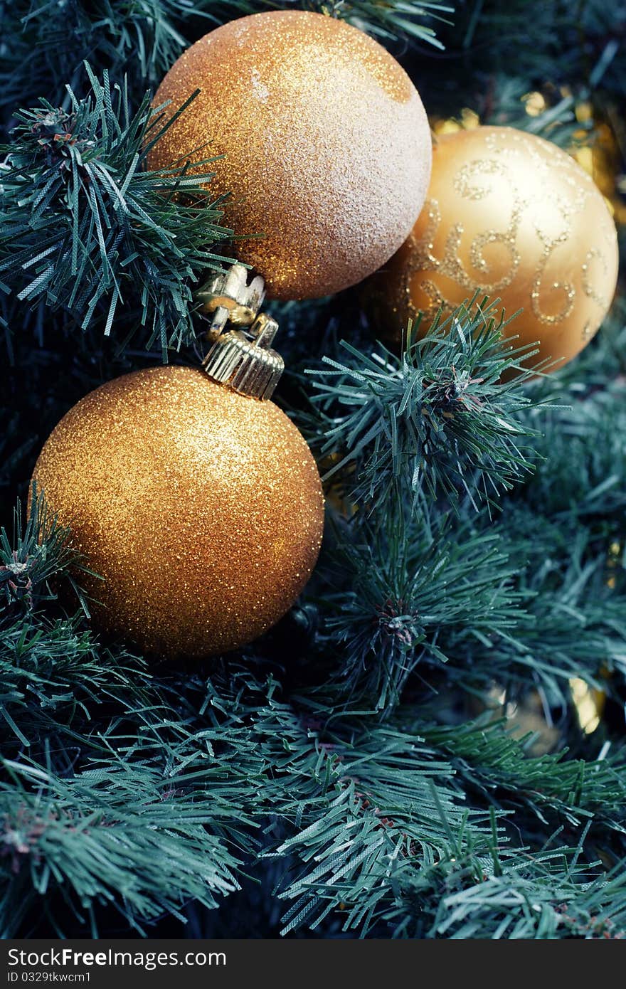 Gold christmas decoration ball on a branch of the christmas-tree. Gold christmas decoration ball on a branch of the christmas-tree