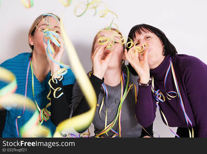 Two young women and her mother celebrating New year's eve. Shot taken in front of white background. Two young women and her mother celebrating New year's eve. Shot taken in front of white background