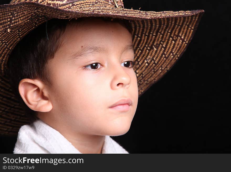 Six years old child looking with hat on black background