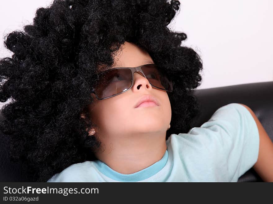 Relaxed child resting in a wig and glasses