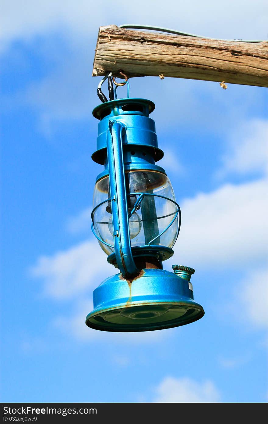 Old blue lantern hanging by wood on the sky. Old blue lantern hanging by wood on the sky