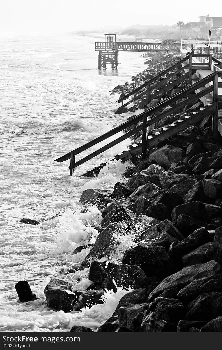 Black and white photo of waves crashing into the rocks on the shoreline. Black and white photo of waves crashing into the rocks on the shoreline