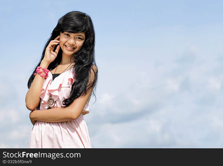 Portrait of young teenage girl smiling in blue sky background. Portrait of young teenage girl smiling in blue sky background