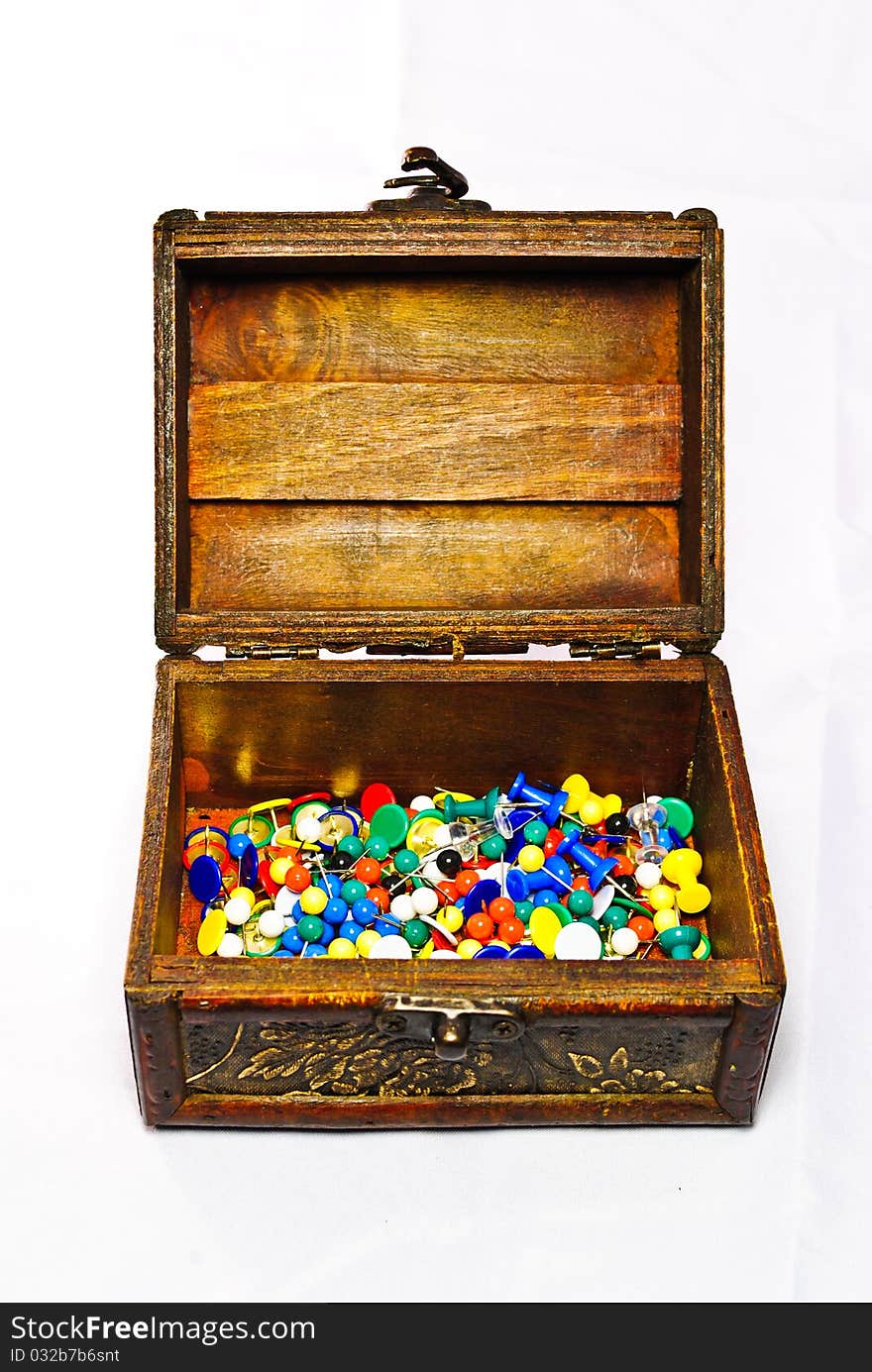 Brown opened chest filled with many colored pins. Brown opened chest filled with many colored pins