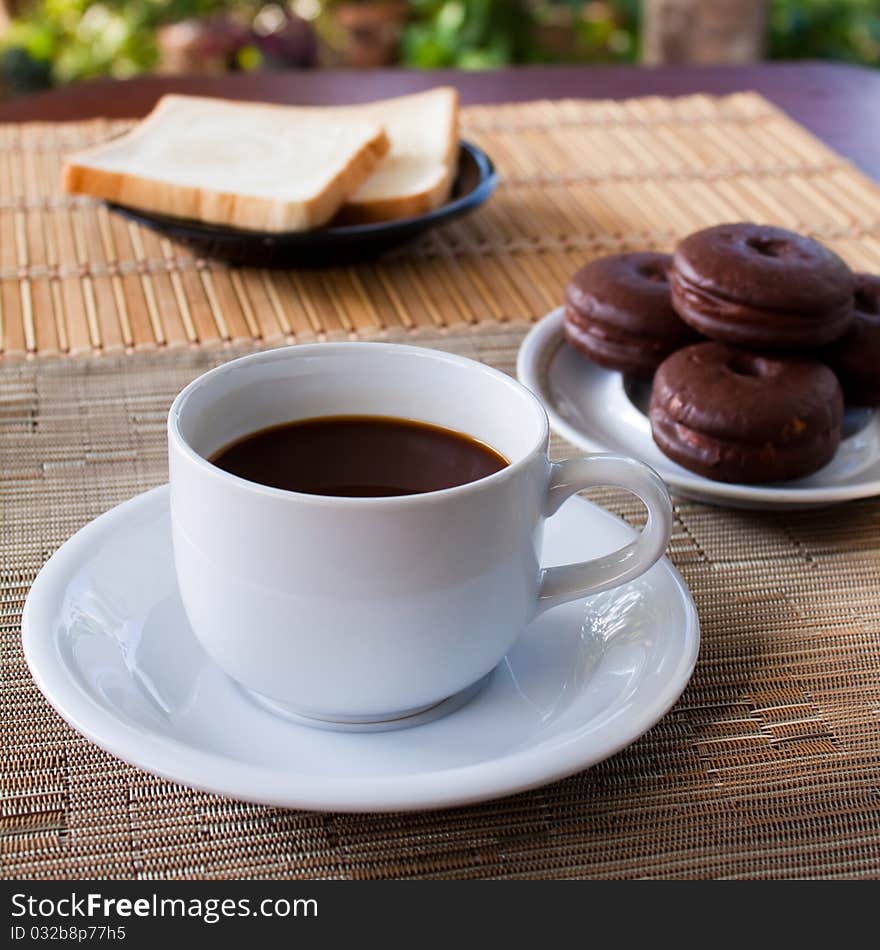 Cup of coffee and bread on table