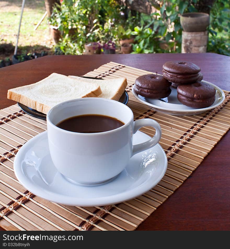 Cup of coffee and bread on table