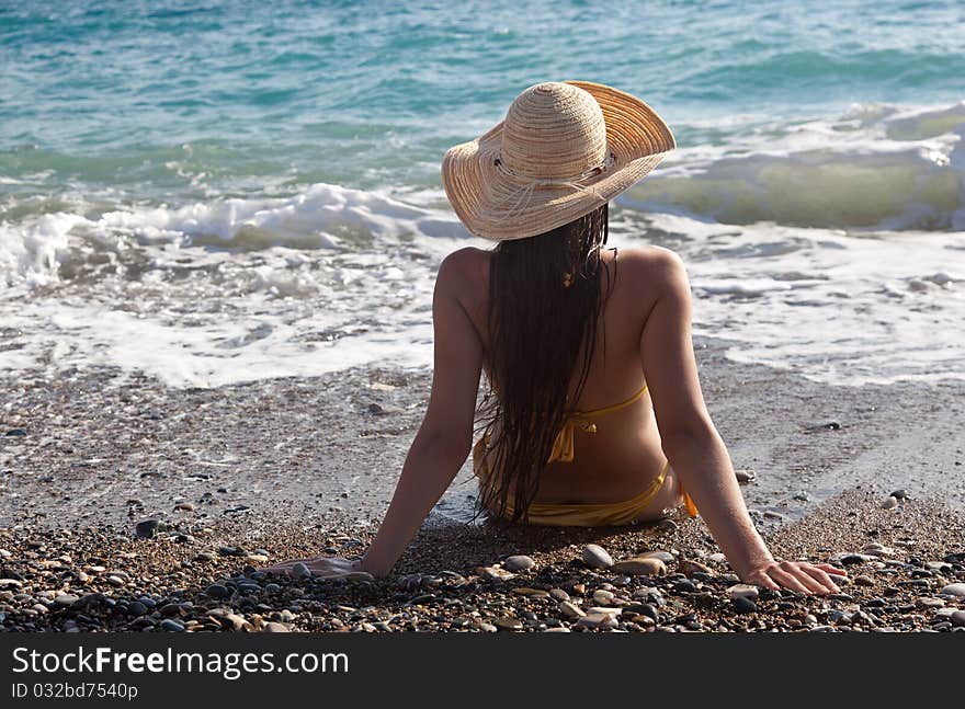 A woman in a bonnet is looking to the sea. A woman in a bonnet is looking to the sea