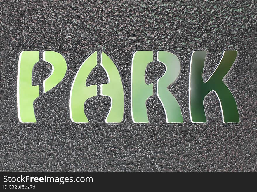 Park sign formed by steel and blurred natural green background.