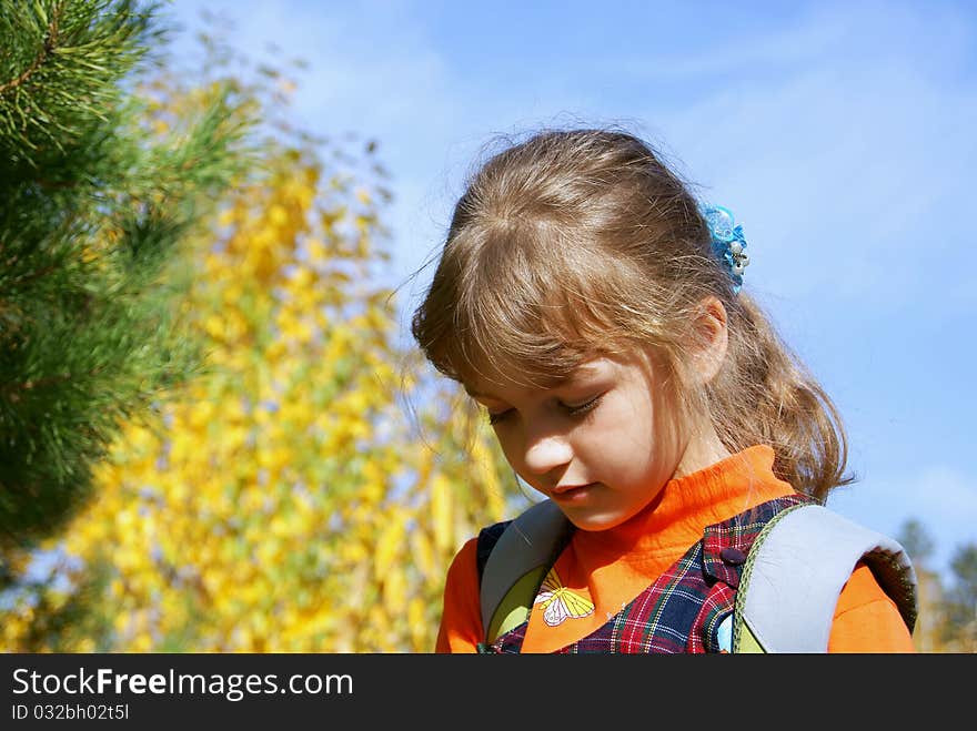 The schoolgirl stands in the autumn in park having hung downwards a head. The schoolgirl stands in the autumn in park having hung downwards a head