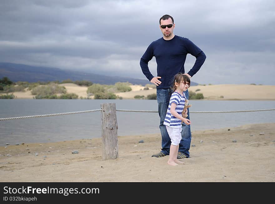 Father and daughter near the mountain lake