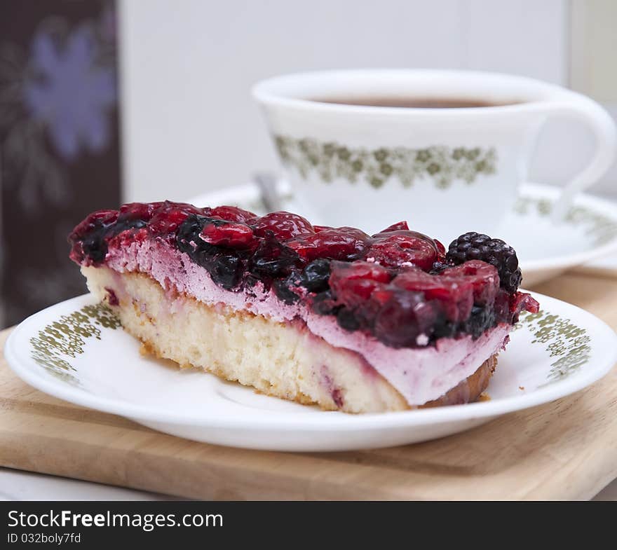 A cup of coffee and a piece of berry pie. A cup of coffee and a piece of berry pie