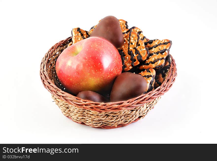 Sweet cookies and ripe apple in the wicker plate. Sweet cookies and ripe apple in the wicker plate