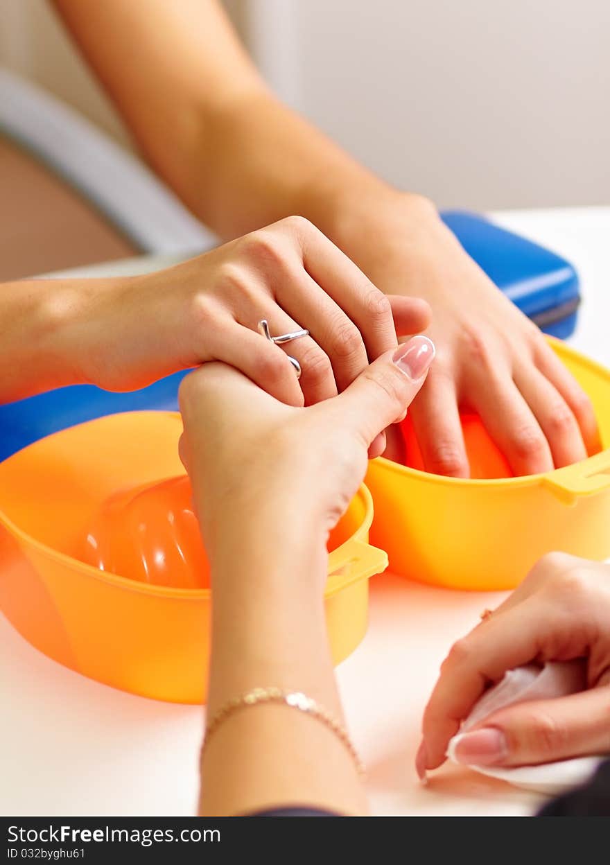 Young woman getting a manicure in a nail salon.