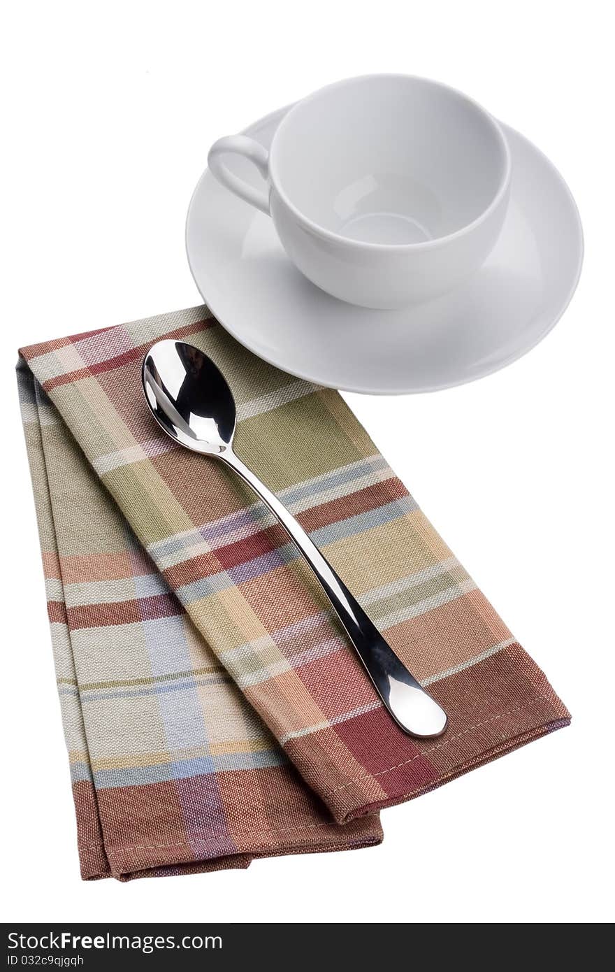 Two spoons on a checkered cloth, tissue.