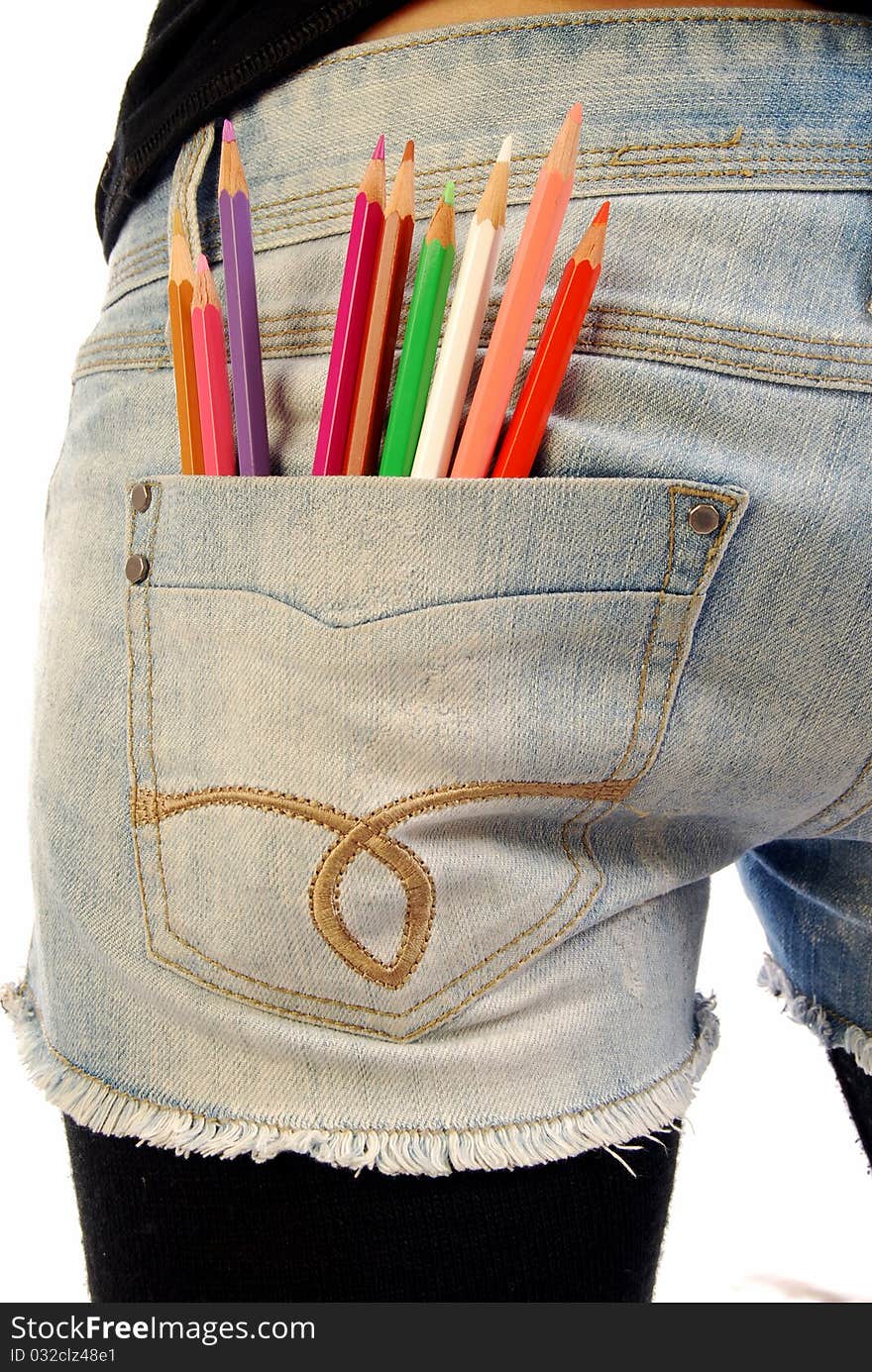 A girl with a set of colored pencils in the pocket of Jeans. A girl with a set of colored pencils in the pocket of Jeans