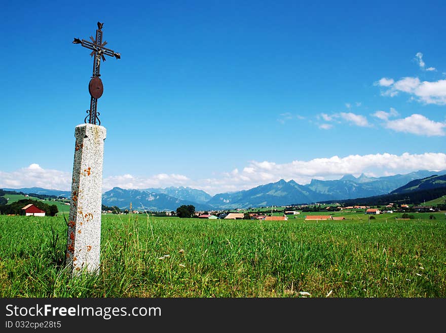 Swiss Alps landscape with a cross in a rural part of Switzerland.