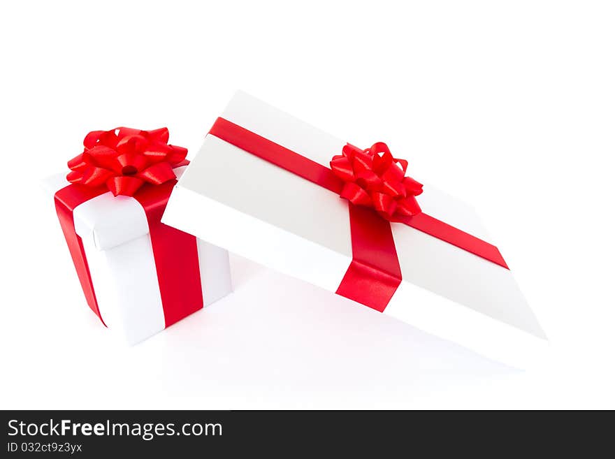 White gift boxes with red ribbon and bow isolated on white