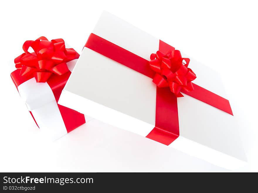 White gift boxes with red ribbon and bow isolated on white