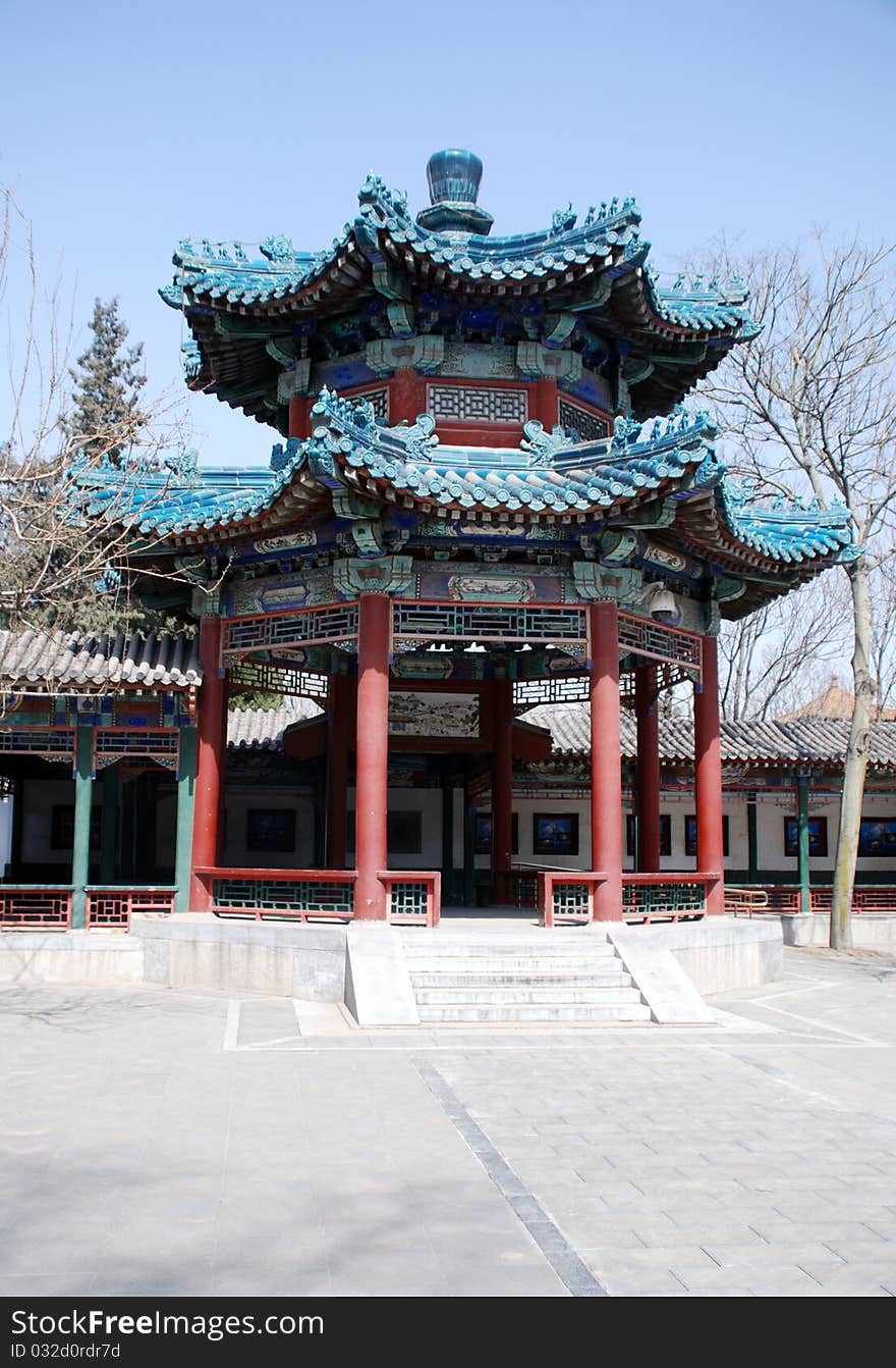 Traditional chinese ornate pavilion with tile roof and trees in early spring. In garden near Forbidden city(Beijing). Traditional chinese ornate pavilion with tile roof and trees in early spring. In garden near Forbidden city(Beijing).