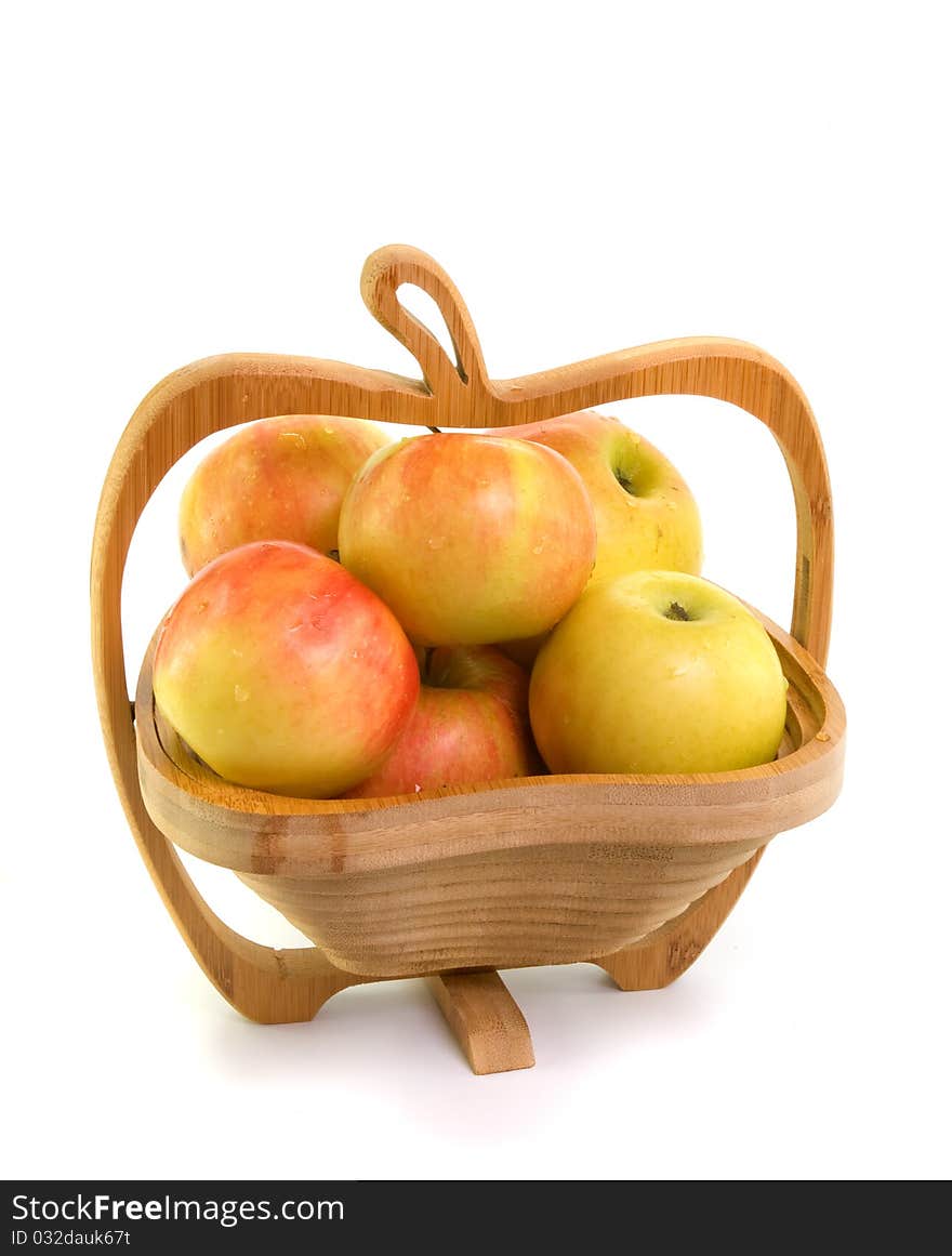 Apples in wooden bowl on white background