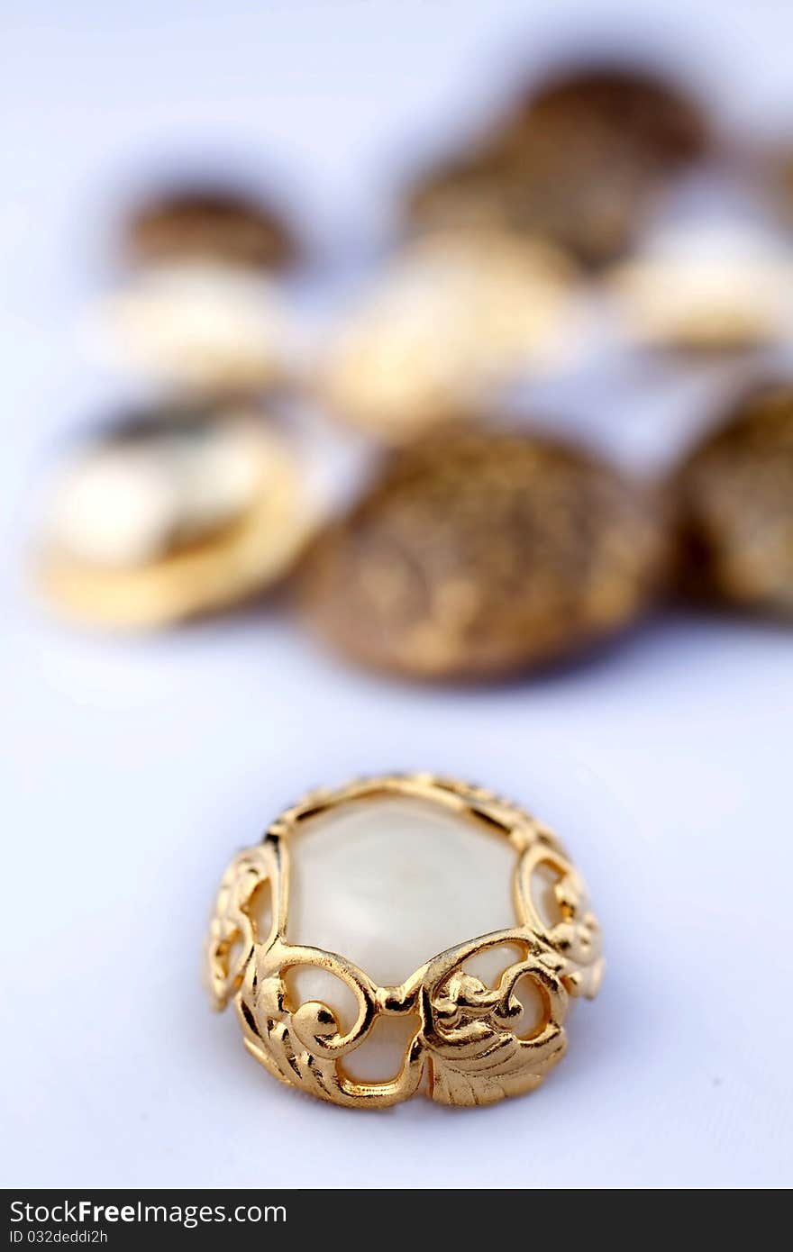 Closeup on group of vintage buttons. Focus on gold and mother-of-pearl one. Closeup on group of vintage buttons. Focus on gold and mother-of-pearl one.