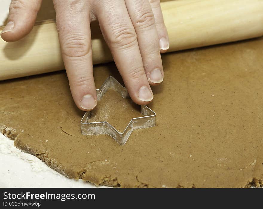 Pressing a star shape cookie cutter into cookie dough. Pressing a star shape cookie cutter into cookie dough