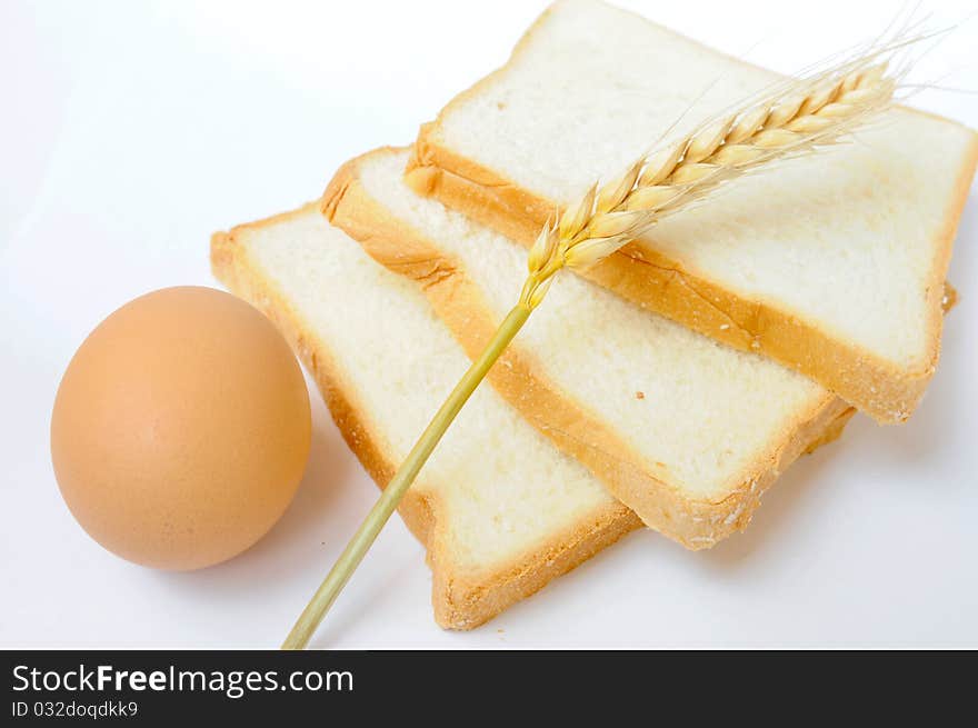 Bread,egg and wheat ear on white background