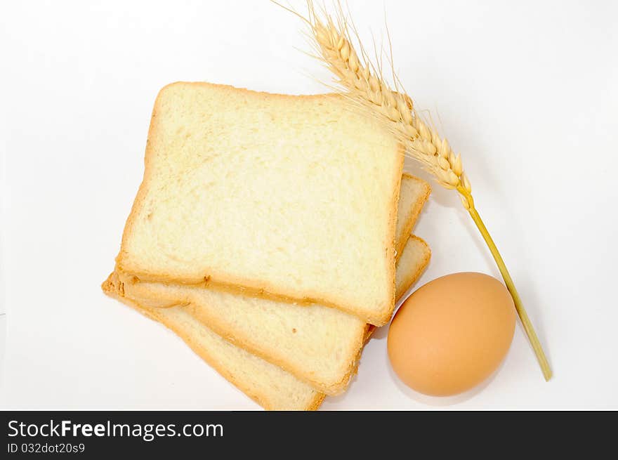 Bread,egg and wheat ear on white background