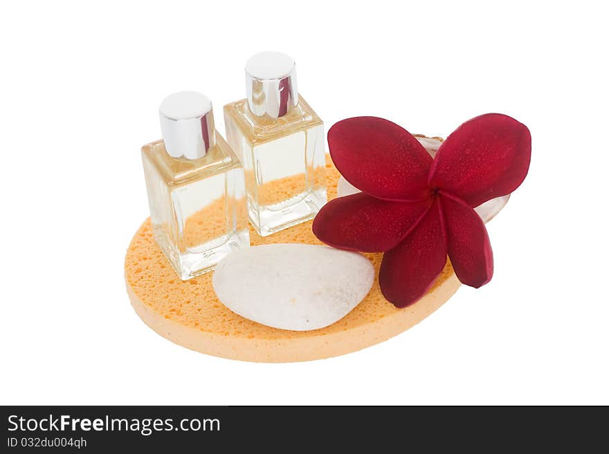 Perfume bottles, white stone and red plumeria on orange sponge. Perfume bottles, white stone and red plumeria on orange sponge