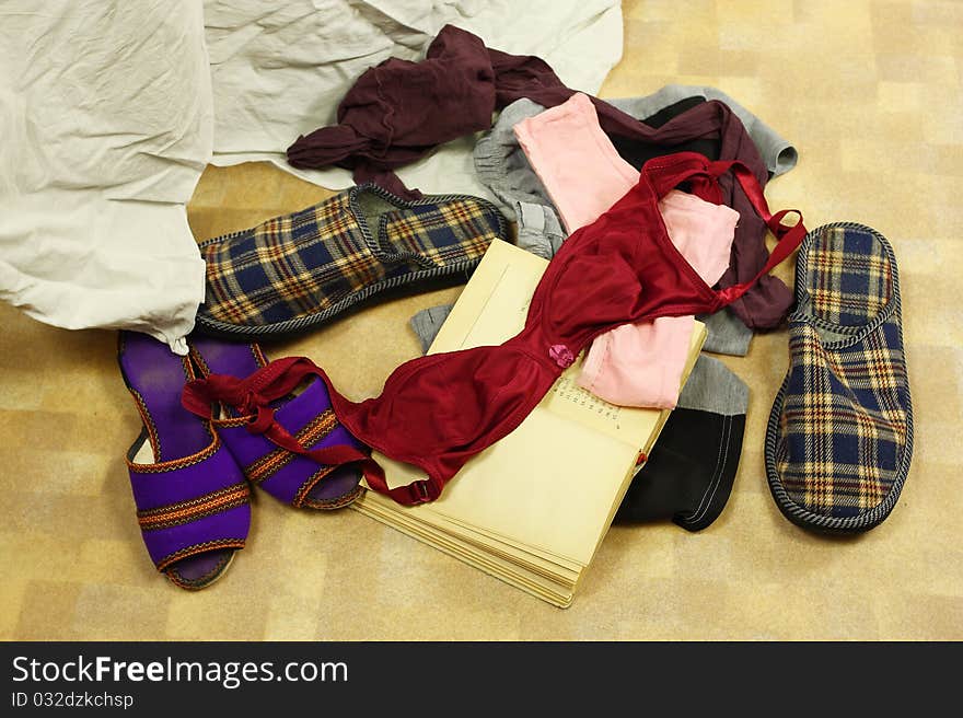 Man's and women underclothes lie on the flore near the bed. Man's and women underclothes lie on the flore near the bed