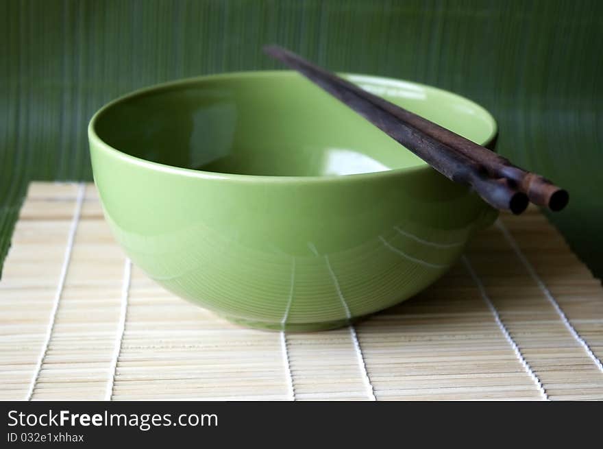 Green bowl and chopsticks on Bamboo pad. Green bowl and chopsticks on Bamboo pad.