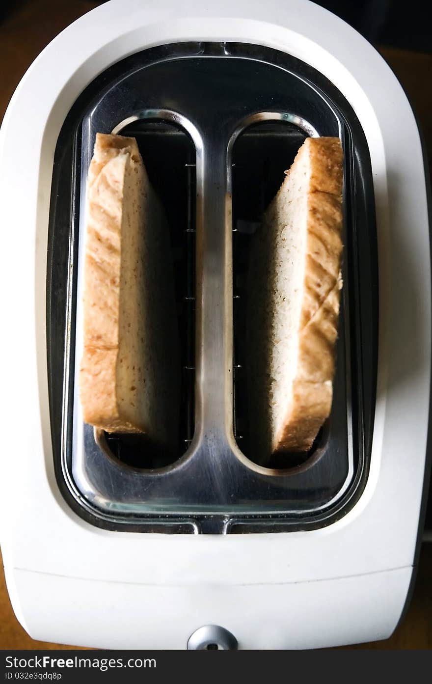 Wheat bread on top in white toaster.